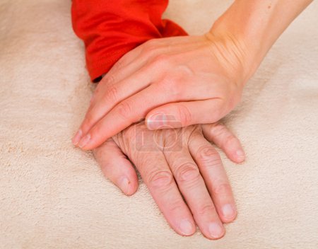 Photo for Elderly womans hand protected by young carer hand - Royalty Free Image