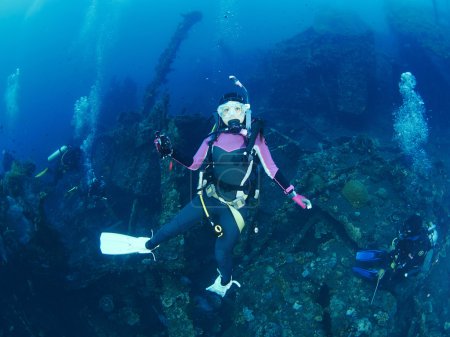 Photo for Scuba diver with a camera swims over a colorful tropical coral reef. - Royalty Free Image