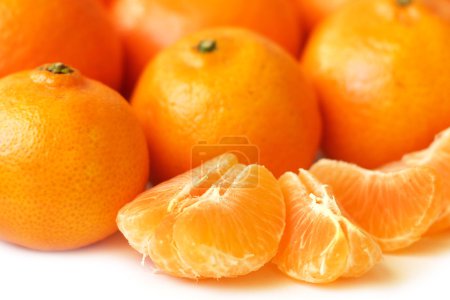 Rebanadas de mandarina y mandarinas enteras
