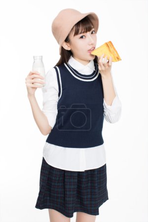 Foto de Bonita chica c hinese, ella pan y fruta en la habitación. En el fondo blanco - Imagen libre de derechos