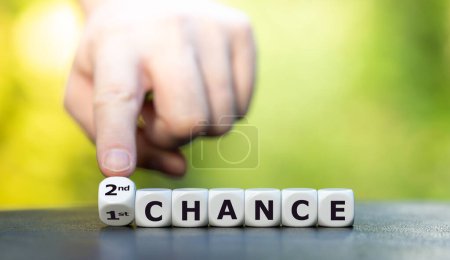 Hand dreht Würfel und ändert den Ausdruck "1. Chance" in "2. Chance"".