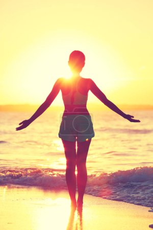 Mindfulness woman practicing yoga sun salutation at beach morning sunrise