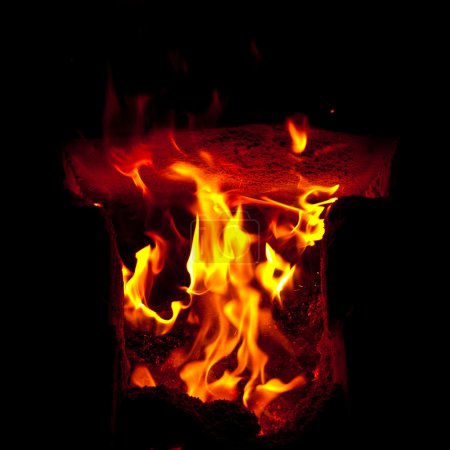 Flames erupt from the combustion chamber of the furnace, on a black background