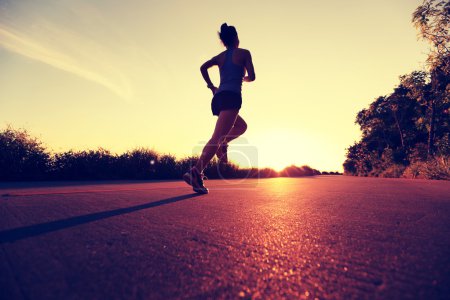 Foto de Joven mujer de fitness corriendo por el sendero del amanecer - Imagen libre de derechos