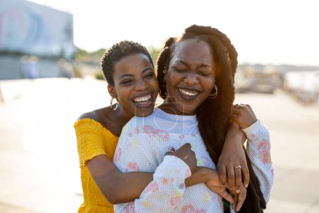 Mujeres jóvenes felices disfrutando del aire libre al atardecer 