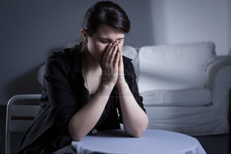 Foto de Desesperación mujer divorciada sentada a la mesa y llorando - Imagen libre de derechos