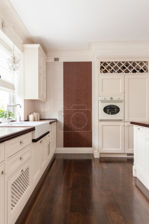 Photo for Picture of modern white furnished kitchen with brown floor - Royalty Free Image