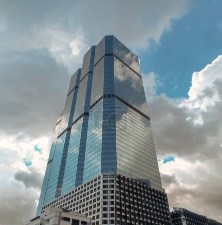 Photo for Bangkok, Thailand - July 10, 2019 :  Angular geometric mirror cladding on a modern building with repeating structure and reflected sky and clouds. No focus, specifically. - Royalty Free Image
