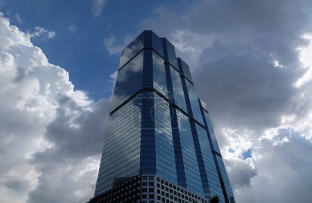 Photo for Bangkok, Thailand - July 10, 2019 :  Angular geometric mirror cladding on a modern building with repeating structure and reflected sky and clouds. No focus, specifically. - Royalty Free Image