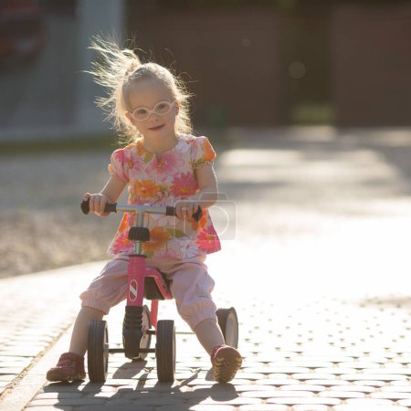 hermosa chica con síndrome de Down montar en bicicleta