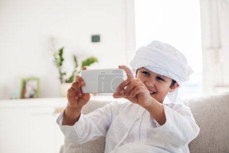 Photo for Arabian Boy Using Smartphone At Home - Royalty Free Image