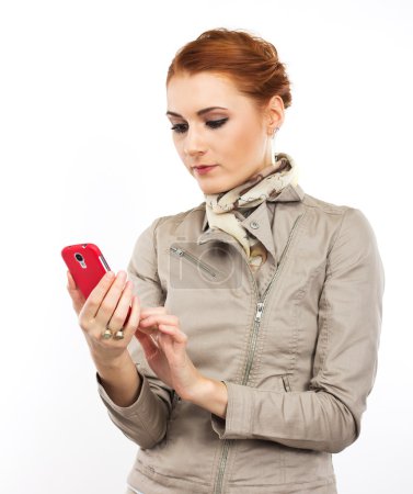 Téléchargez les photos : Jeune fille élégante avec un smartphone à la main. Smartphone framboise. Portrait de fille mince sur un fond blanc - en image libre de droit