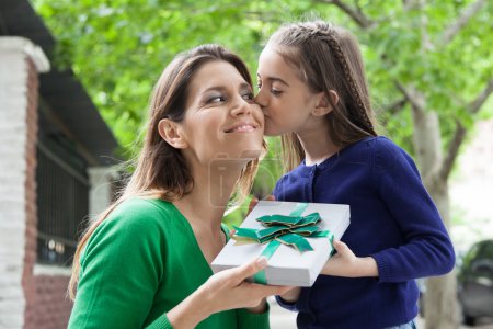 Chica dando a su madre un regalo de Navidad
