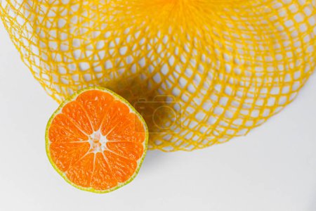 orange and lime and Ripe green and yellow tangerines and orange tangerine slices on a white background