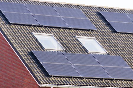 Paneles solares en un techo marrón para la generación de energía eléctrica Paneles solares en un techo marrón para la generación de energía eléctrica