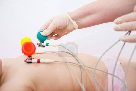 Photo for The child is being prepared for an electrocardiogram of the heart, diagnosis of heart disease in children - Royalty Free Image