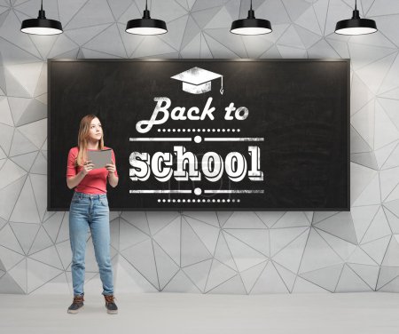 La joven está reflexionando sobre el futuro año académico. Palabras: 'volver a la escuela' están escritas en la pizarra negra
. La joven está reflexionando sobre el futuro año académico. Palabras: 'volver a la escuela' están escritas en la pizarra negra
.