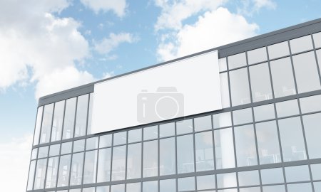 A billboard on the facade of a glass and metal office building. White background. Concept of outdoors advertising. 3D rendering