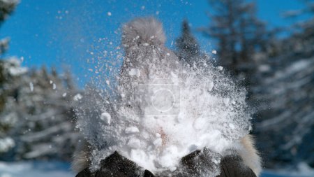 Téléchargez les photos : FERMER, PORTRAIT, DOF : Boule de neige moelleuse éclaboussures comme il rencontre le visage de la femme méconnaissable. Plan drôle d'une touriste se faisant frapper au visage par une boule de neige alors qu'elle s'implique dans un combat de neige. - en image libre de droit