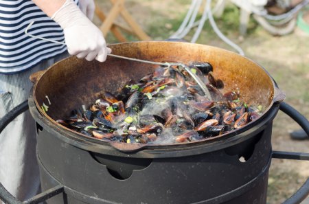 Olla grande de mejillones calientes al vapor que cocina al aire libre
