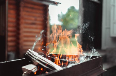 A burning firewood in the outdoor fire pit