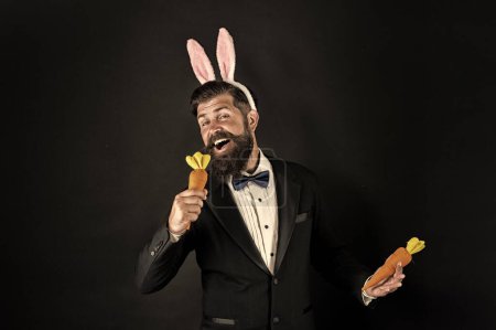 Siente la canción. Cantante de Pascua. El hombre de negocios finge cantar con zanahoria. El barbudo canta la canción fondo negro. Disfrutando de la canción de Pascua. Canción de karaoke. Concierto de música. Humor y melodía. Como música para mis oídos