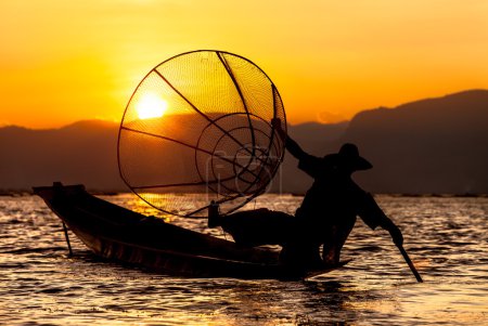 Puesta de sol y pescador en el lago Inle
