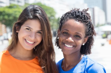 kaukasische Mädchen und afrikanisch-amerikanische Mädchen in der Stadt