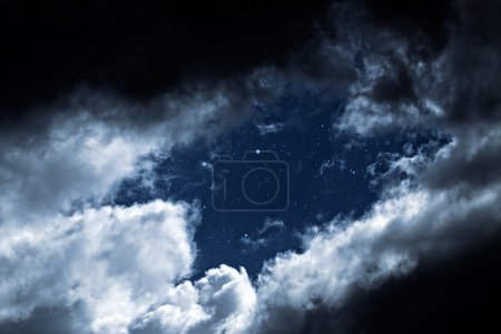 Photo for Cloudy night with a hole in the clouds revealing the stars - Royalty Free Image