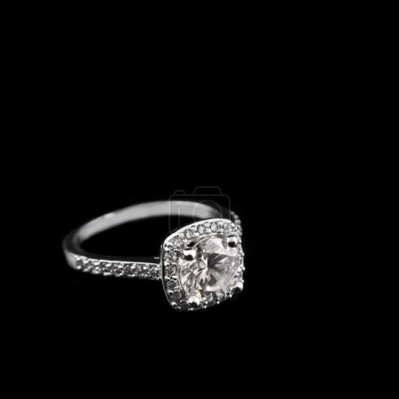 Joyas de lujo. Sortija de compromiso en oro blanco o plata con diamantes en primer plano sobre fondo negro. Enfoque selectivo
.