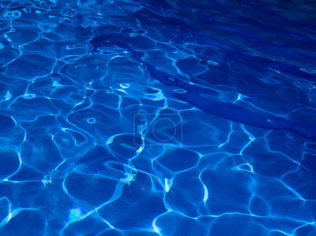 Textura azul abstracta del agua de la piscina con reflejos