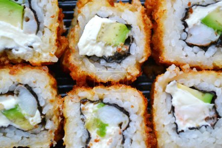 Deliciosos panecillos y sushi con camarones, pepino y filadelfia

