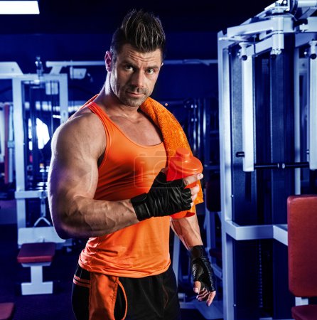 Espalda muscular del entrenamiento de culturistas jóvenes en fondo oscuro
