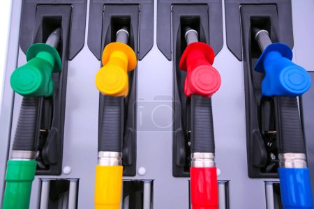 Detalle de una bomba de gasolina en una gasolinera. Primer plano en la boquilla de combustible en el dispensador de aceite con gasolina y diesel en la gasolinera de servicio. Azul, verde, rojo, colores dorados Detalle de una bomba de gasolina en una gasolinera. Primer plano en la boquilla de combustible en el dispensador de aceite con gasolina y diesel en la gasolinera de servicio. Azul, verde, rojo, colores dorados