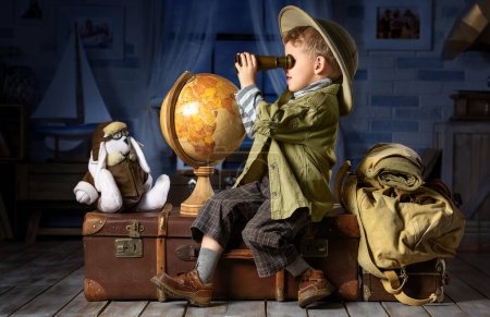 Niño pequeño se imagina a sí mismo un turista y juega en su habitación