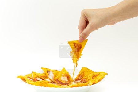 Pincking tortila chips covered with cheese (Nachos) from white d