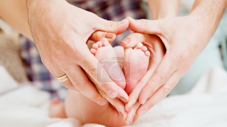Los pies de los niños en manos de la madre y el padre
.