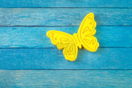 Papillon jaune décoratif sur fond de bois bleu 