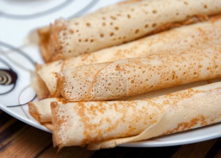 Deliciosos rollos de crepé en placa blanca
.