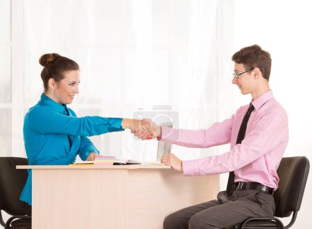 Foto de Hombre y mujer - una entrevista de trabajo o reunión de negocios. Estudiante masculino vino a la oficina para conseguir un trabajo. HR Manager realiza la primera entrevista. De acuerdo. Discutir las posibilidades de la cooperación empresarial
. - Imagen libre de derechos