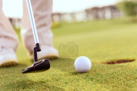 Foto de Golpeándolo suavemente Primer plano del hombre que va a poner la bola en el agujero con la ayuda del club de golf - Imagen libre de derechos