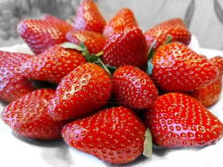 Photo for Ripe red large strawberries on a white plate - Royalty Free Image