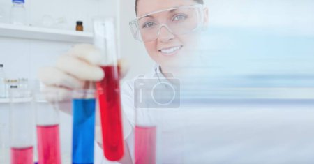Foto de Composición de científica femenina en laboratorio sosteniendo tubo de ensayo con desenfoque de movimiento. concepto de ciencia y tecnología de investigación imagen generada digitalmente. - Imagen libre de derechos