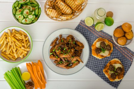 Fiesta deportiva - alas de pollo, verduras, papas fritas, pizza
