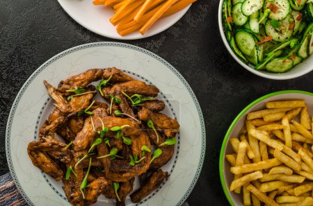 Téléchargez les photos : Ailes de poulet, légumes, frites, pizza, beignets, jus de lime, trempette, salade de concombre et pain grillé
. - en image libre de droit