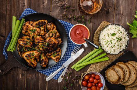 Photo for Grilled chicken wings with hot and spicy chili sauce, baked bread with seeds, jasmine rice with herbs and beer - Royalty Free Image