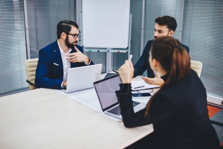 Male and female proud ceo communicating about productive solution for business project cooperating in modern office interior, executive managers dressed in formal wear discussing trade exchange