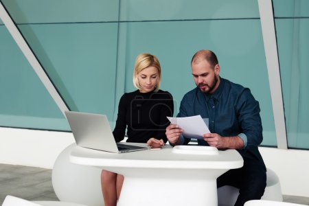 Photo for Man boss reading resume of new employees while sitting with his partner at the table with open net-book, team of skilled leaders using laptop computer and paper documents for developing a new project - Royalty Free Image