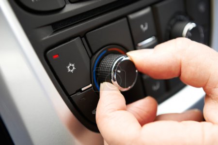 Primer plano de la mano de ajuste de aire acondicionado del coche de control en el lavabo
