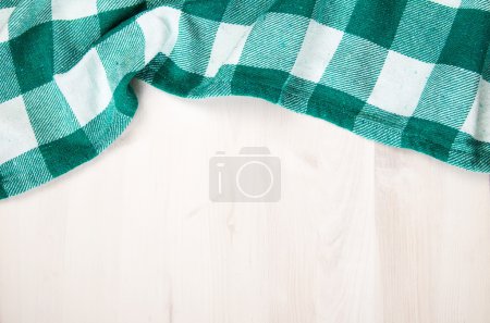 Photo for Green folded tablecloth over bleached wooden table - Royalty Free Image